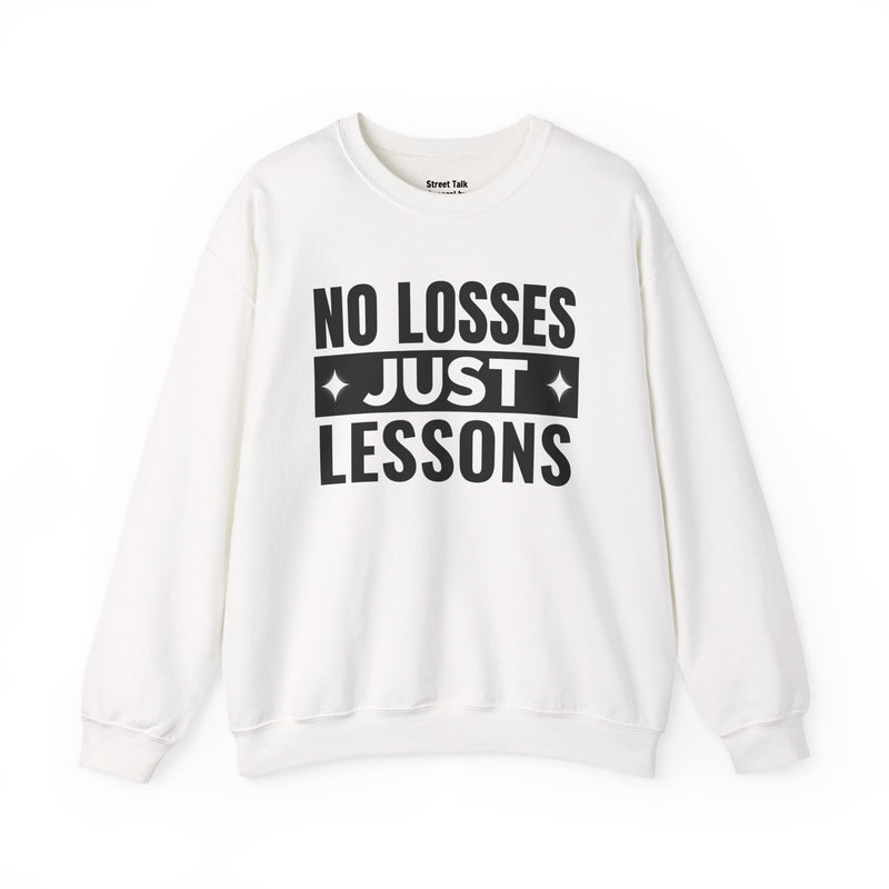White sweatshirt with black block lettering reading NO LOSSES JUST LESSONS, front view.