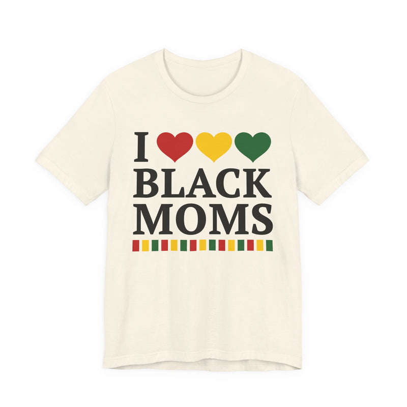 Front flat-lay of the I Love Black Moms t-shirt in Natural: black 'I' with red, gold, and green hearts above black 'BLACK MOMS' collegiate lettering, with a red, gold, and green stripe bar beneath the text.