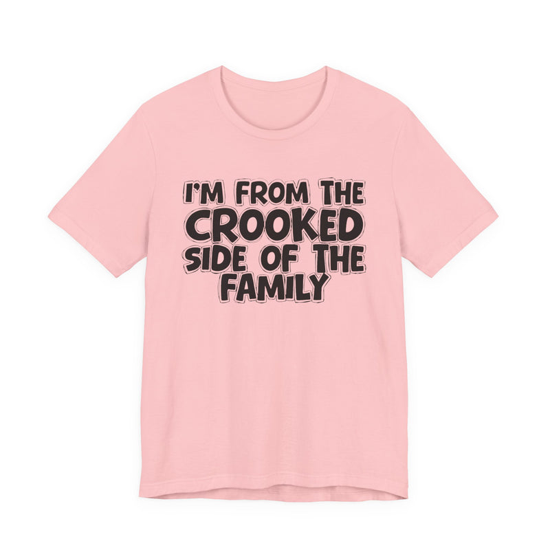 Pink t-shirt, printed with the "I'M FROM THE CROOKED SIDE OF THE FAMILY" statement in bold outlined bubble lettering, front flat-lay view.