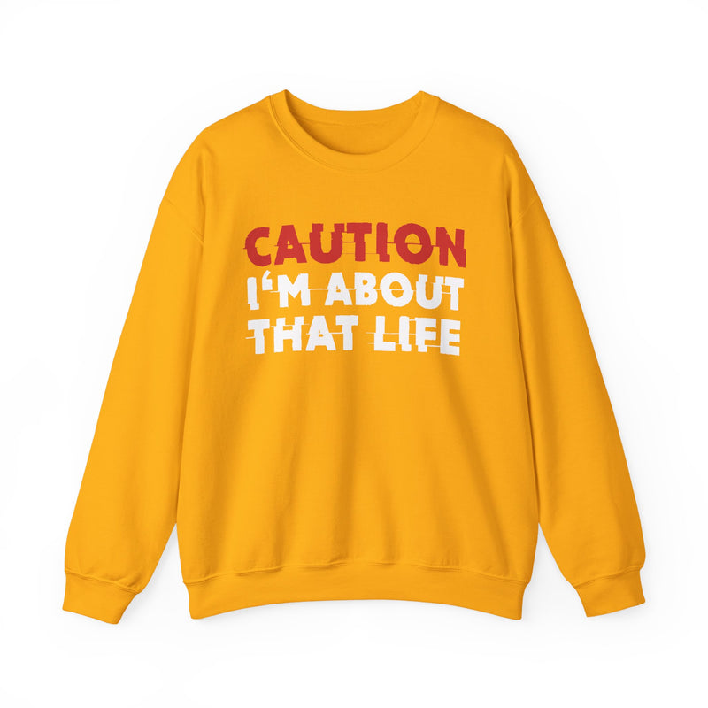 Sweatshirt in Gold with lettering reading "CAUTION I'M ABOUT THAT LIFE", front view.
