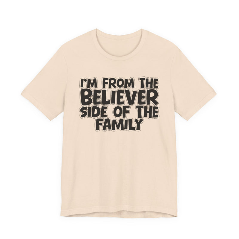 Soft Cream t-shirt with white outlined bubble lettering reading 'I'M FROM THE BELIEVER SIDE OF THE FAMILY', front flat-lay view.