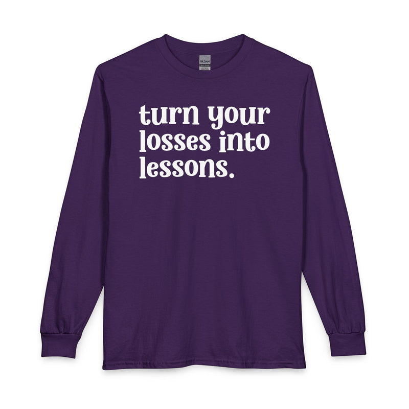 Purple long sleeve t-shirt with white "turn your losses into lessons." lettering, front view.