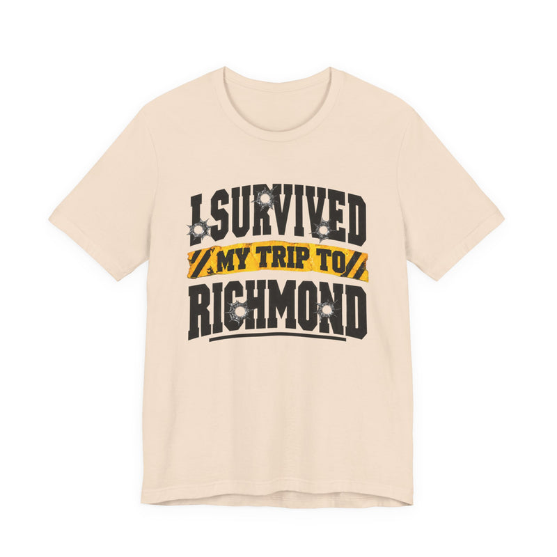 T-Shirt product photo with arched collegiate lettering reading "I SURVIVED" with bullet-hole decals, a caution-tape band reading "MY TRIP TO", and large block letters reading "RICHMOND", front view.
