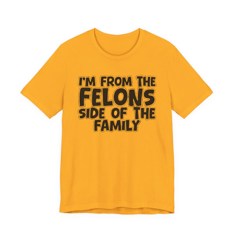 Gold t-shirt with white outlined bubble lettering reading 'I'M FROM THE FELONS SIDE OF THE FAMILY', front flat-lay view.