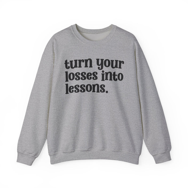 Sport grey crewneck sweatshirt with black "turn your losses into lessons." lettering, front view.