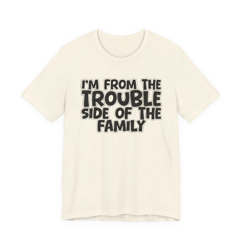 Natural t-shirt, printed with the "I'M FROM THE TROUBLE SIDE OF THE FAMILY" statement in bold outlined bubble lettering, front flat-lay view.