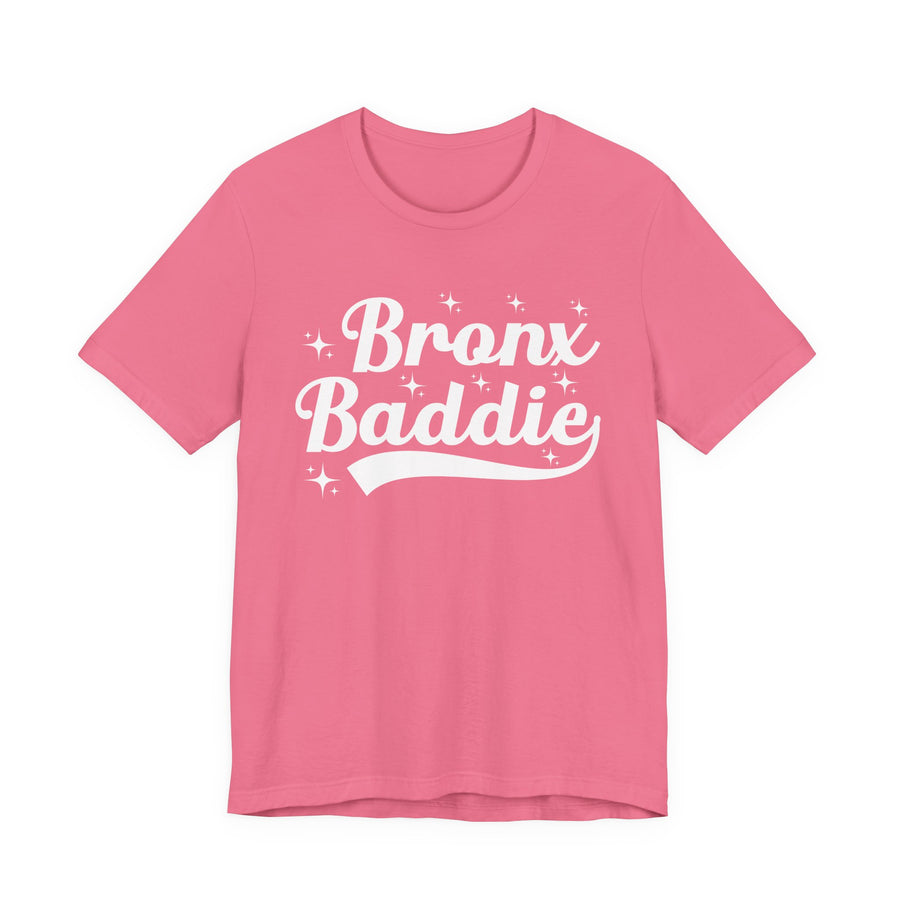 Pink t-shirt with white bold statement lettering reading BRONX BEAUTY, front flat-lay view.