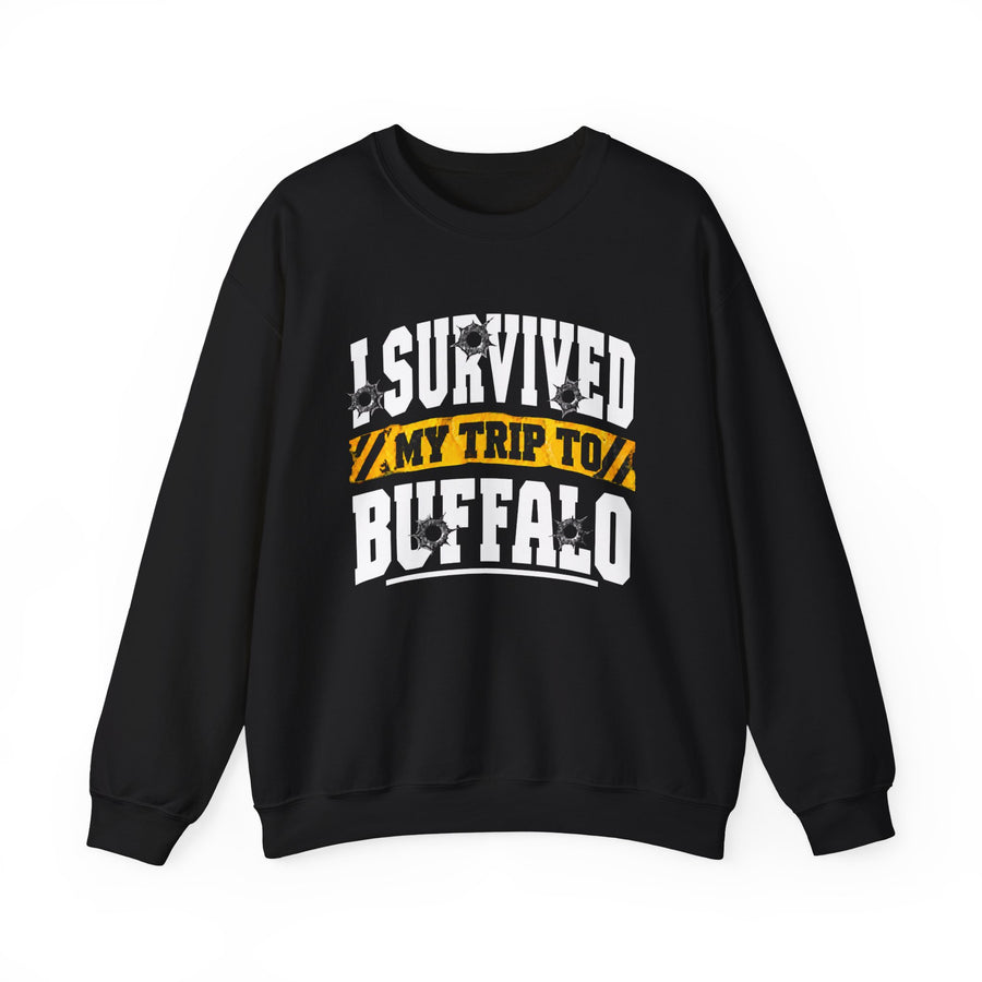 Sweatshirt product photo with arched collegiate lettering reading "I SURVIVED" with bullet-hole decals, a caution-tape band reading "MY TRIP TO", and large block letters reading "BUFFALO", front view.
