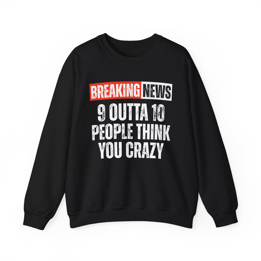 BREAKING NEWS banner graphic with distressed headline text '9 OUTTA 10 PEOPLE THINK YOU CRAZY' - sweatshirt in charcoal, front view, product mockup on white background