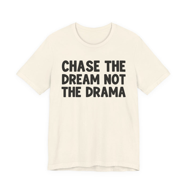 Natural t-shirt with black bold statement lettering reading CHASE THE DREAM NOT THE DRAMA, front flat-lay view.