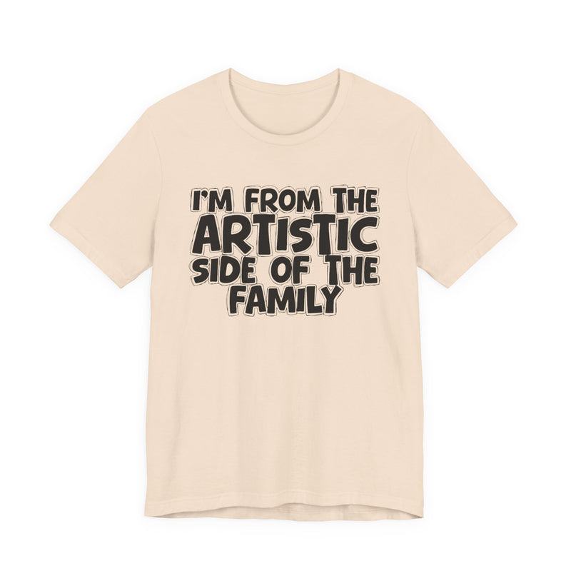 Navy t-shirt with bold chest statement text reading 'I'M FROM THE ARTISTIC SIDE OF THE FAMILY,' front flat-lay view.