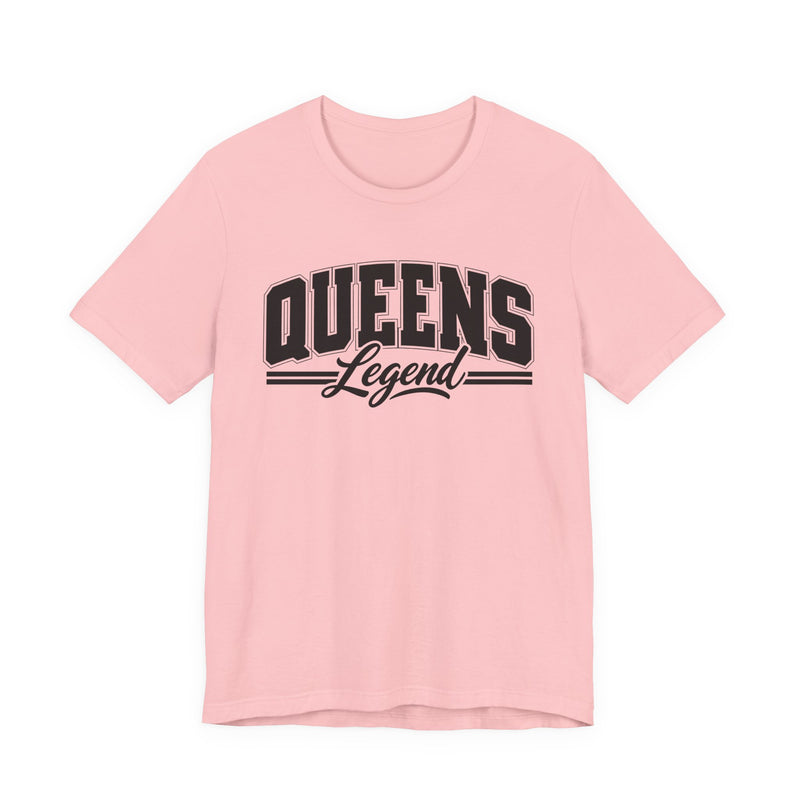 Light pink t-shirt with black varsity block and script lettering reading QUEENS LEGEND, front flat-lay view.