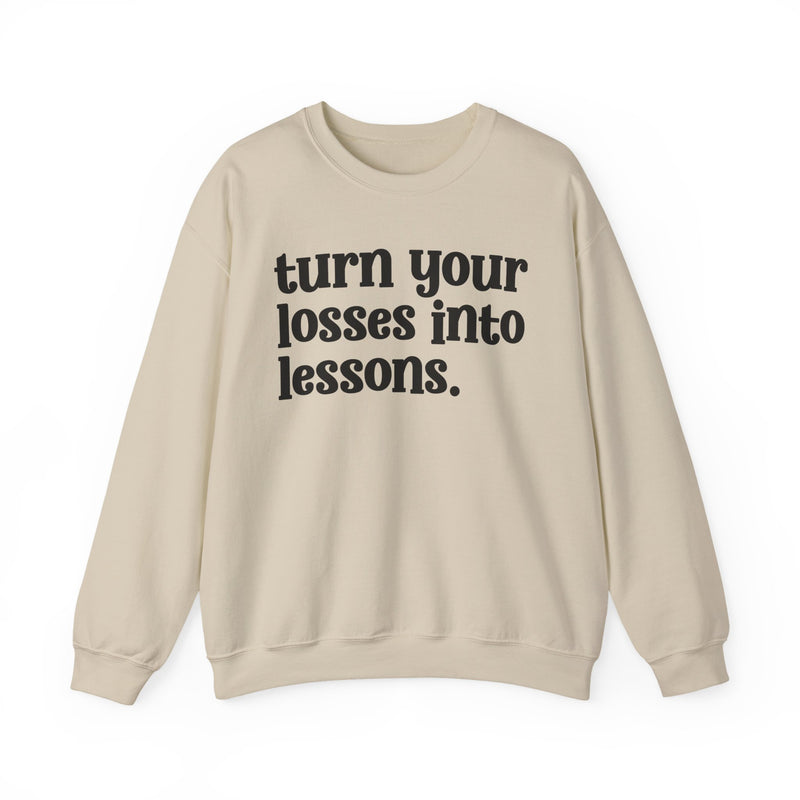 Sand crewneck sweatshirt with black "turn your losses into lessons." lettering, front view.
