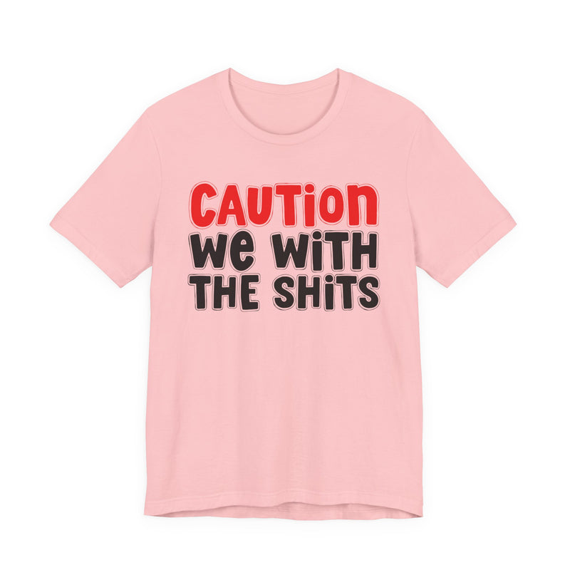 T-Shirt in Pink with lettering reading "CAUTION WE WITH THE SHITS", front view.