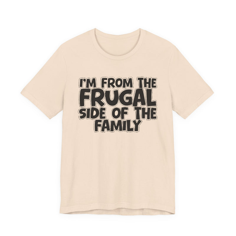 Natural t-shirt with 'I'M FROM THE FRUGAL SIDE OF THE FAMILY' in black hand-drawn bubble lettering on the chest, front flat-lay mockup view.