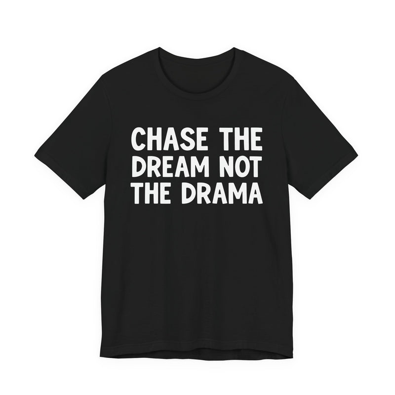 Black t-shirt with white bold statement lettering reading CHASE THE DREAM NOT THE DRAMA, front flat-lay view.