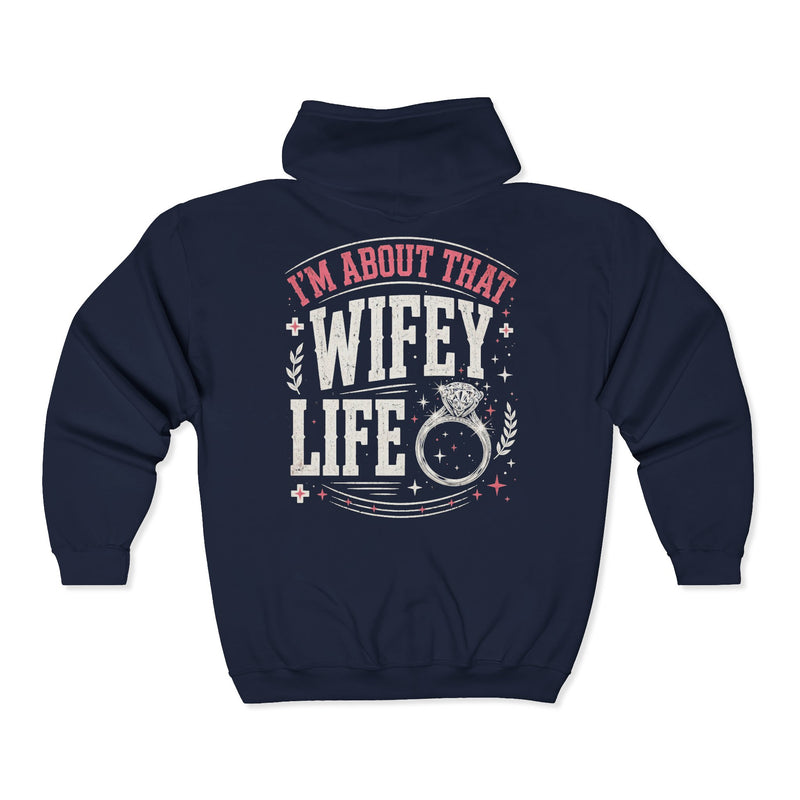 Navy zip hoodie with white and pink western lettering reading "I'M ABOUT THAT WIFEY LIFE", back flat-lay view.