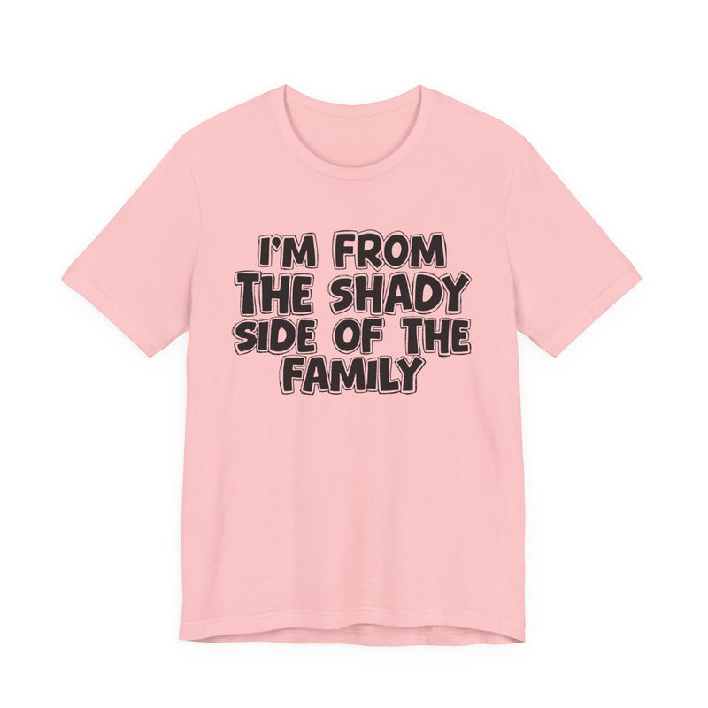 light t-shirt with ‘I’M FROM THE SHADY SIDE OF THE FAMILY’ statement text in bold outline lettering, front flat-lay view.