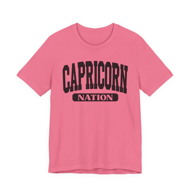 Charity Pink t-shirt with black arched CAPRICORN lettering and a NATION pill badge, front view.