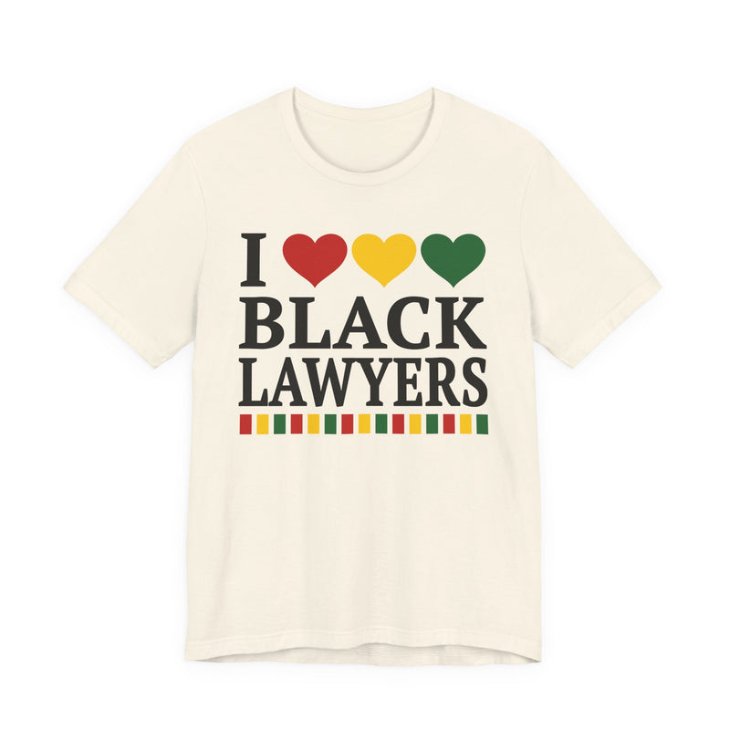 Front flat-lay of the I Love Black Lawyers t-shirt in Natural: black 'I' with red, gold, and green hearts above black 'BLACK LAWYERS' collegiate lettering, with a red, gold, and green stripe bar beneath the text.