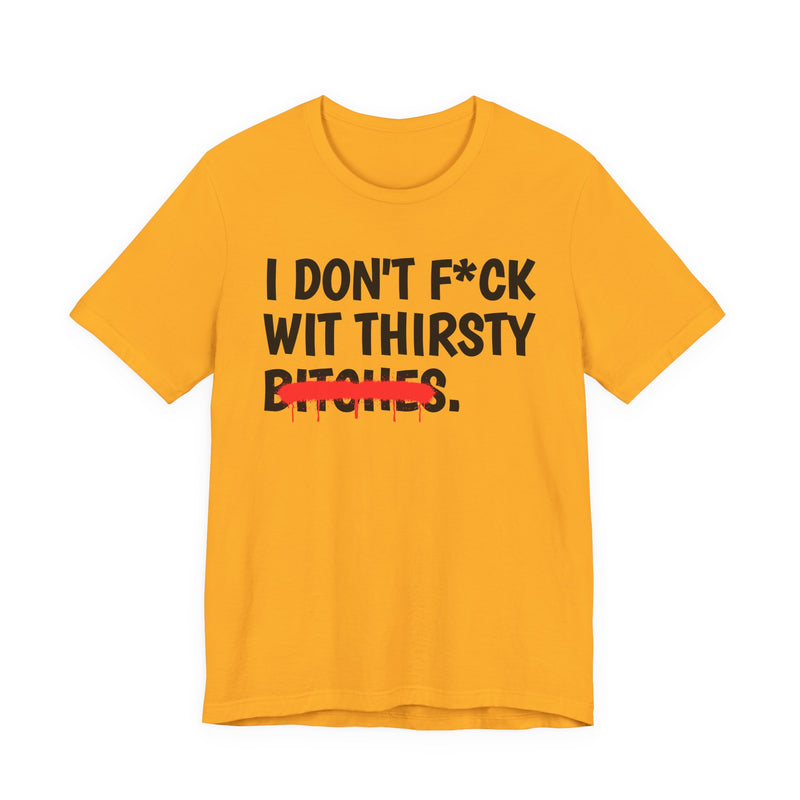 Gold t-shirt with black bold lettering reading I DON'T F*CK WIT THIRSTY BITCHES, crossed by a red dripping strikethrough, front flat-lay view.