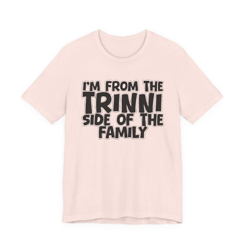 Soft Cream t-shirt with 'I'M FROM THE TRINNI SIDE OF THE FAMILY' in black hand-drawn bubble lettering on the chest, front flat-lay mockup view.