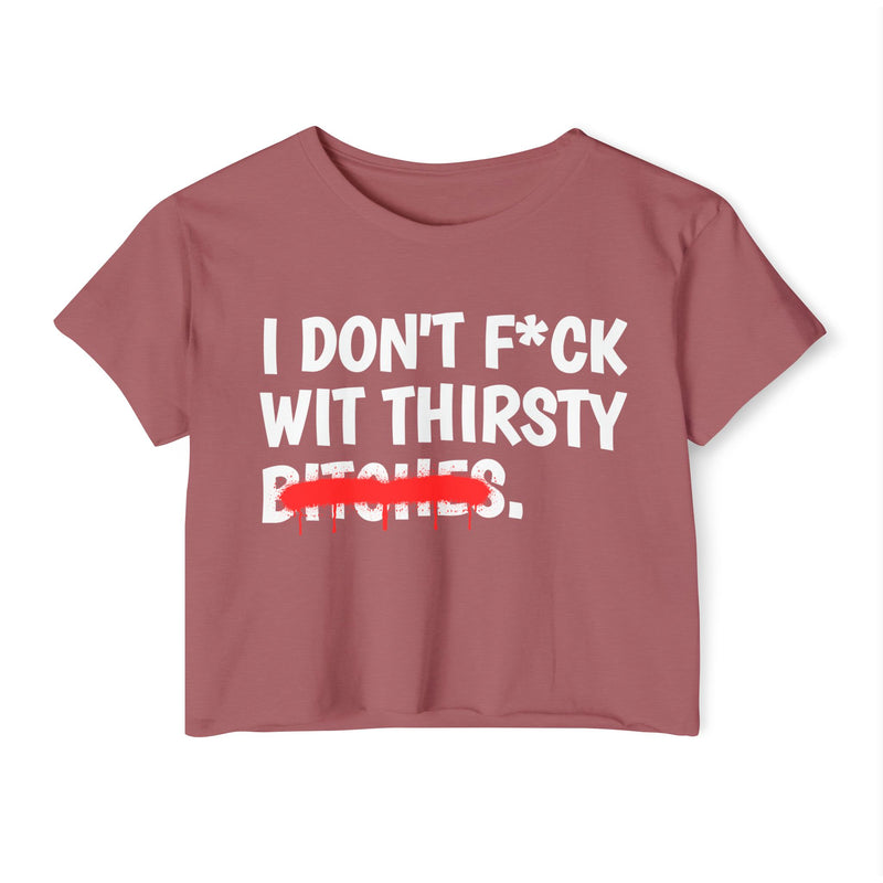 Red crop top with white bold lettering reading I DON'T F*CK WIT THIRSTY BITCHES, crossed by a red dripping strikethrough, front flat-lay view.