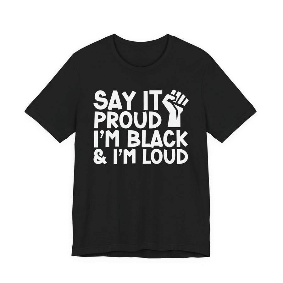 Black t-shirt with stacked text reading SAY IT PROUD, I'M BLACK, I'M LOUD with a raised-fist icon between the lines, front view.