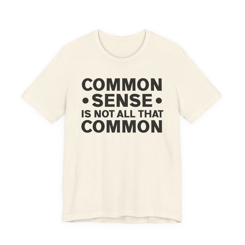 White t-shirt with black collegiate lettering reading COMMON SENSE IS NOT ALL THAT COMMON, flat-lay view.