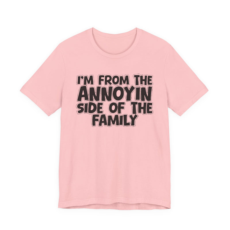light t-shirt with ‘I’M FROM THE ANNOYIN SIDE OF THE FAMILY’ statement text in bold outline lettering, front flat-lay view.