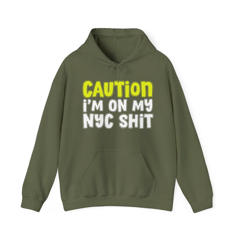 Hoodie in Military Green with lettering reading "CAUTION I’M ON MY NYC SHIT", front view.