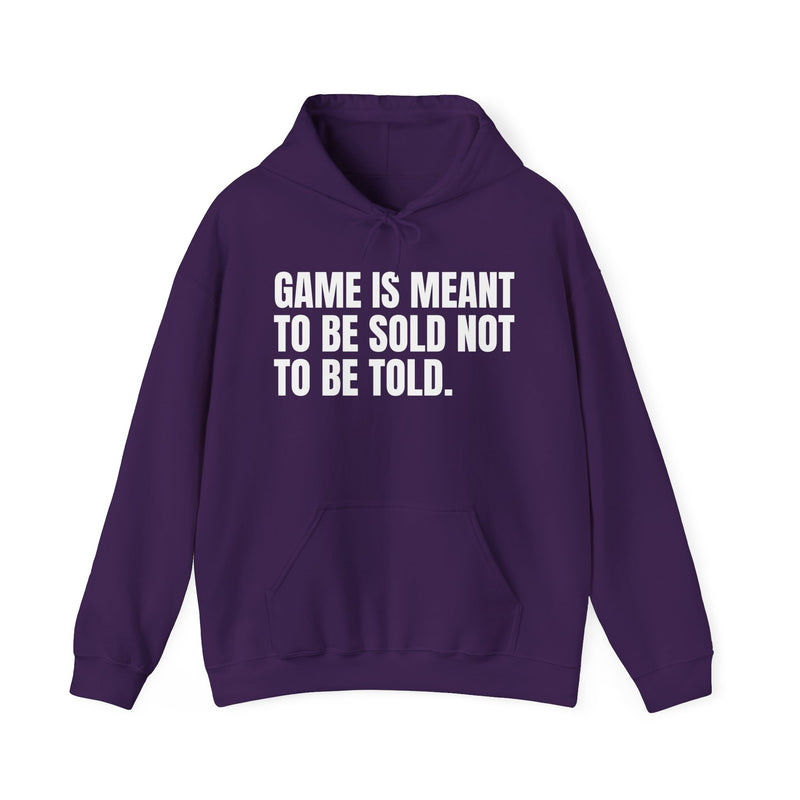 Navy hoodie with white condensed block lettering reading "GAME IS MEANT TO BE SOLD NOT TO BE TOLD.", front flat-lay view.