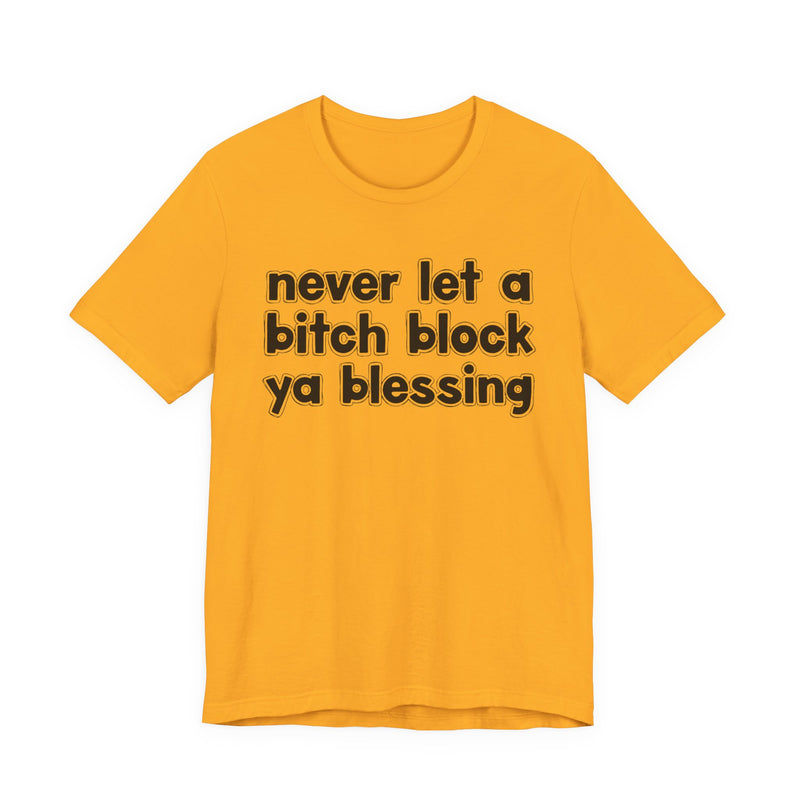 Gold t-shirt with white lettering reading "never let a bitch block ya blessing", front flat-lay view.