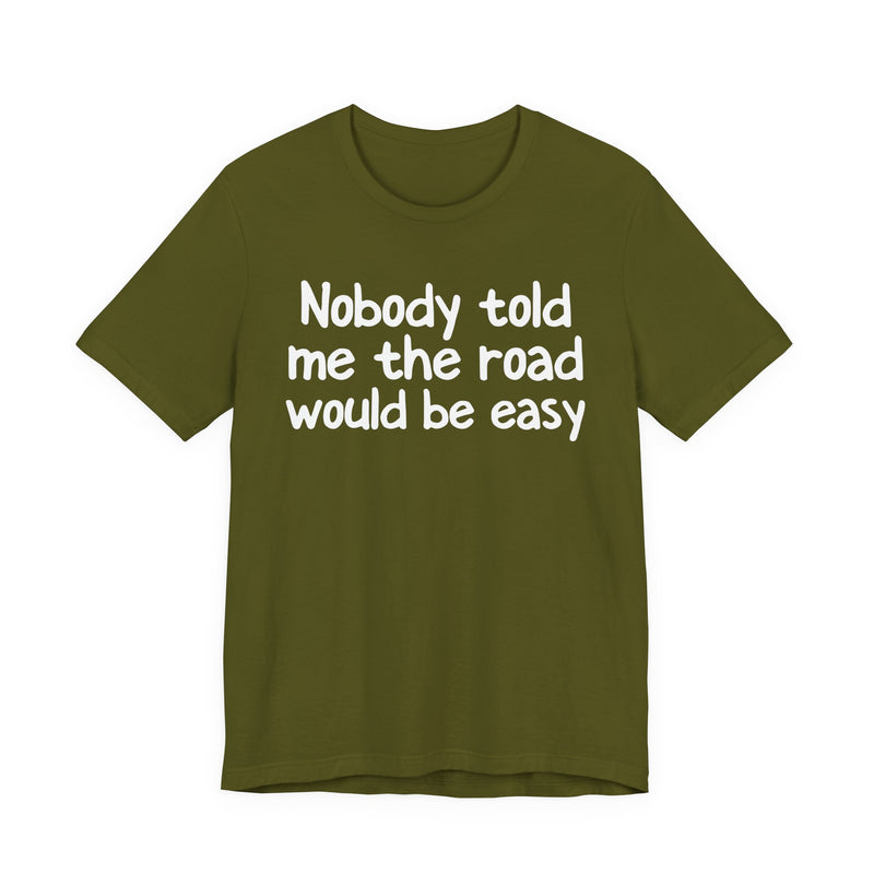 T-Shirt with text design reading “NOBODY TOLD ME THE ROAD WOULD BE EASY”, front view