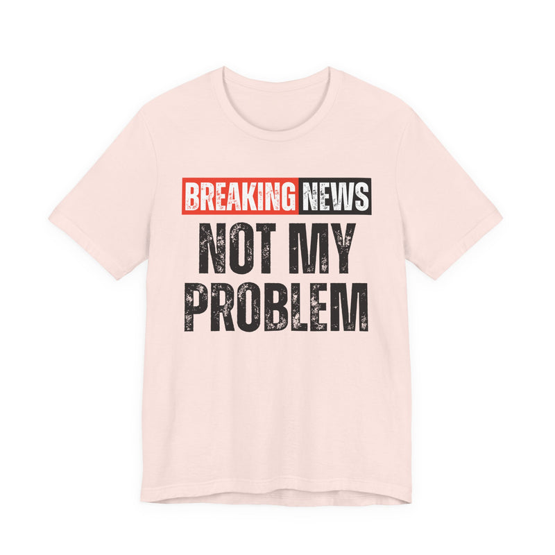 BREAKING NEWS: NOT MY PROBLEM distressed news-bar text design — t-shirt in Soft Pink, front view, product mockup on white background