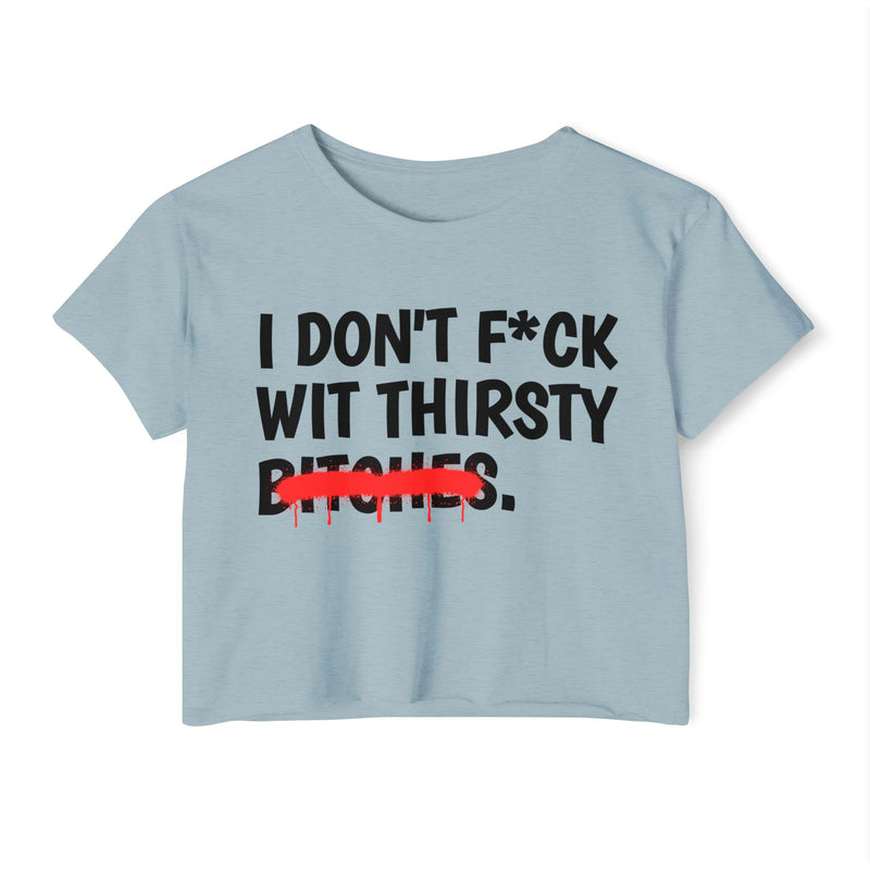Stonewash Denim crop top showing a different design: black stacked uppercase "I DON'T F*CK WIT THIRSTY BITCHES" lettering with a red strikeout through BITCHES, front flat-lay view.
