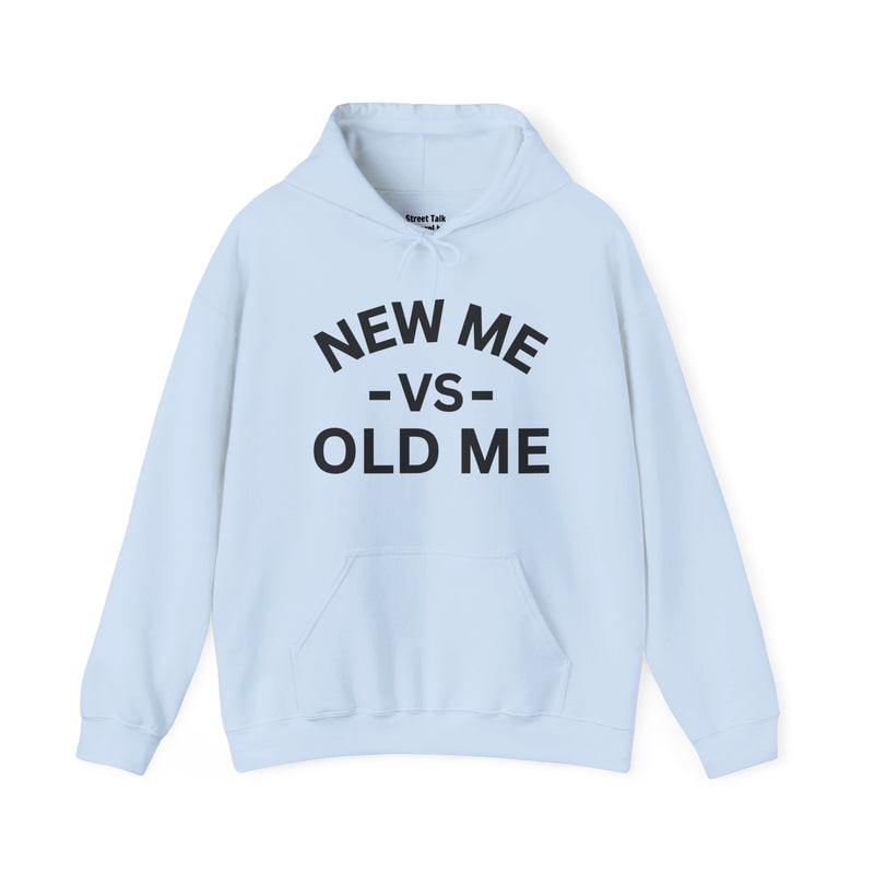 Light blue hoodie with black bold statement lettering reading NEW ME VS OLD ME, front flat-lay view.
