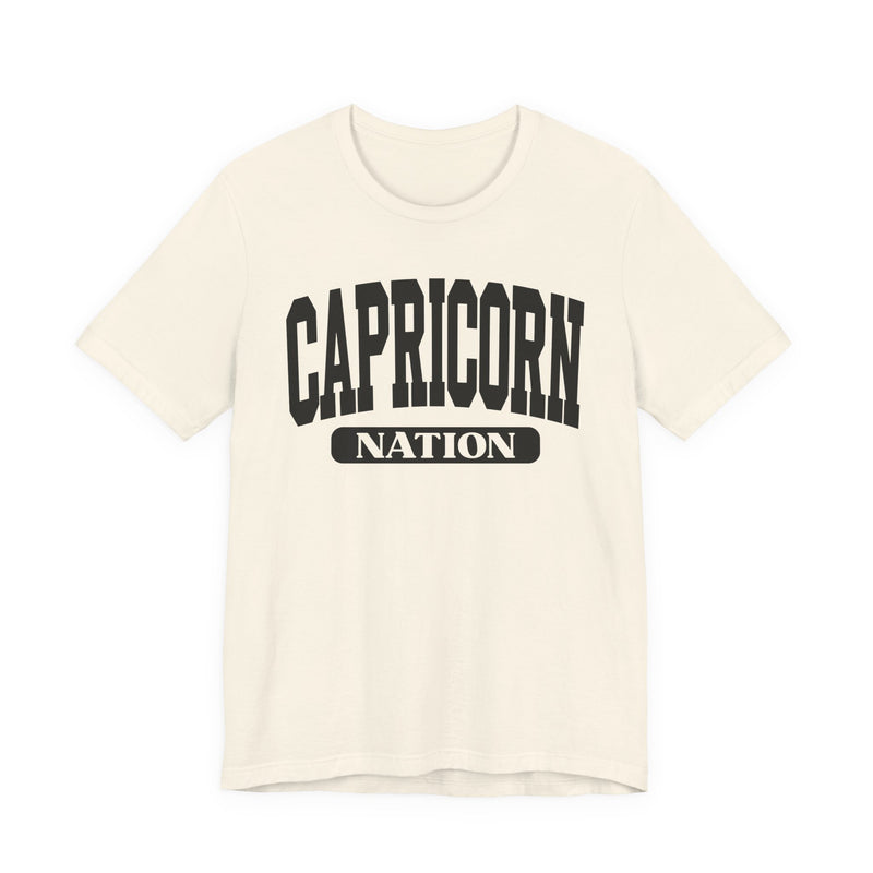 Natural t-shirt with black arched CAPRICORN lettering and a NATION pill badge, front view.
