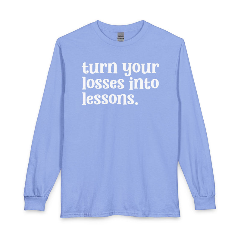 Carolina blue long sleeve t-shirt with white "turn your losses into lessons." lettering, front view.
