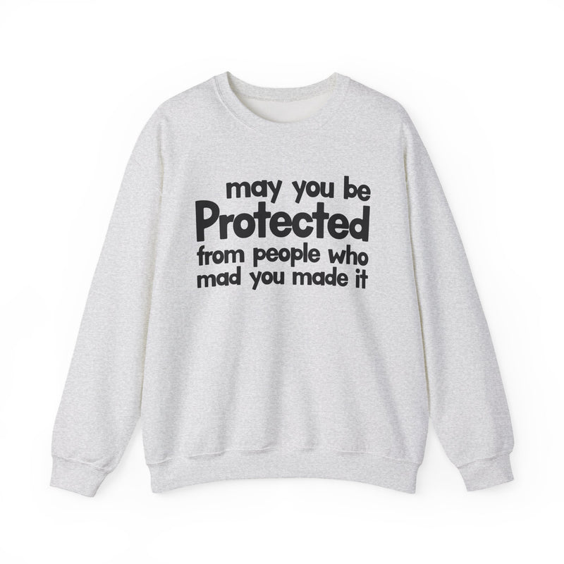 May You Be Protected From People Who Mad You Made It — Sweatshirt fabric detail close-up: MAY YOU BE PROTECTED FROM PEOPLE WHO MAD YOU MADE IT in bold statement lettering. Street Talk Designs protection statement apparel.