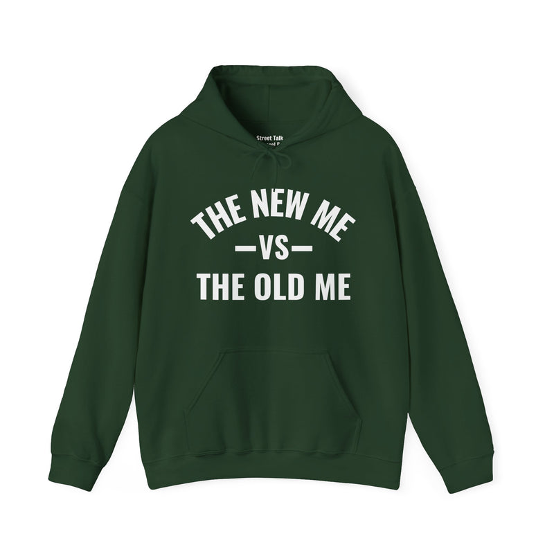 Military green hoodie with dark bold versus-style lettering reading THE NEW ME VS THE OLD ME, front flat-lay view.